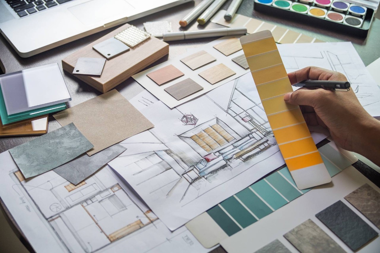 Interior design drawings, paint swatches, and other kinds of material samples spread across a desk near Federal Way, WA