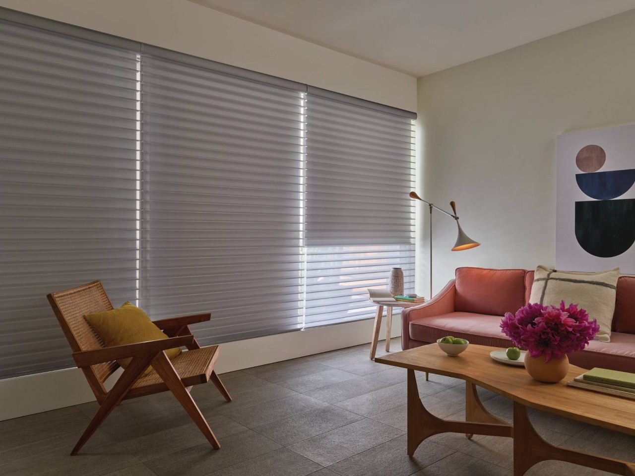 Sitting area with a wooden chair, a couch, and window coverings outfitted with PowerView® Automation near Federal Way, WA