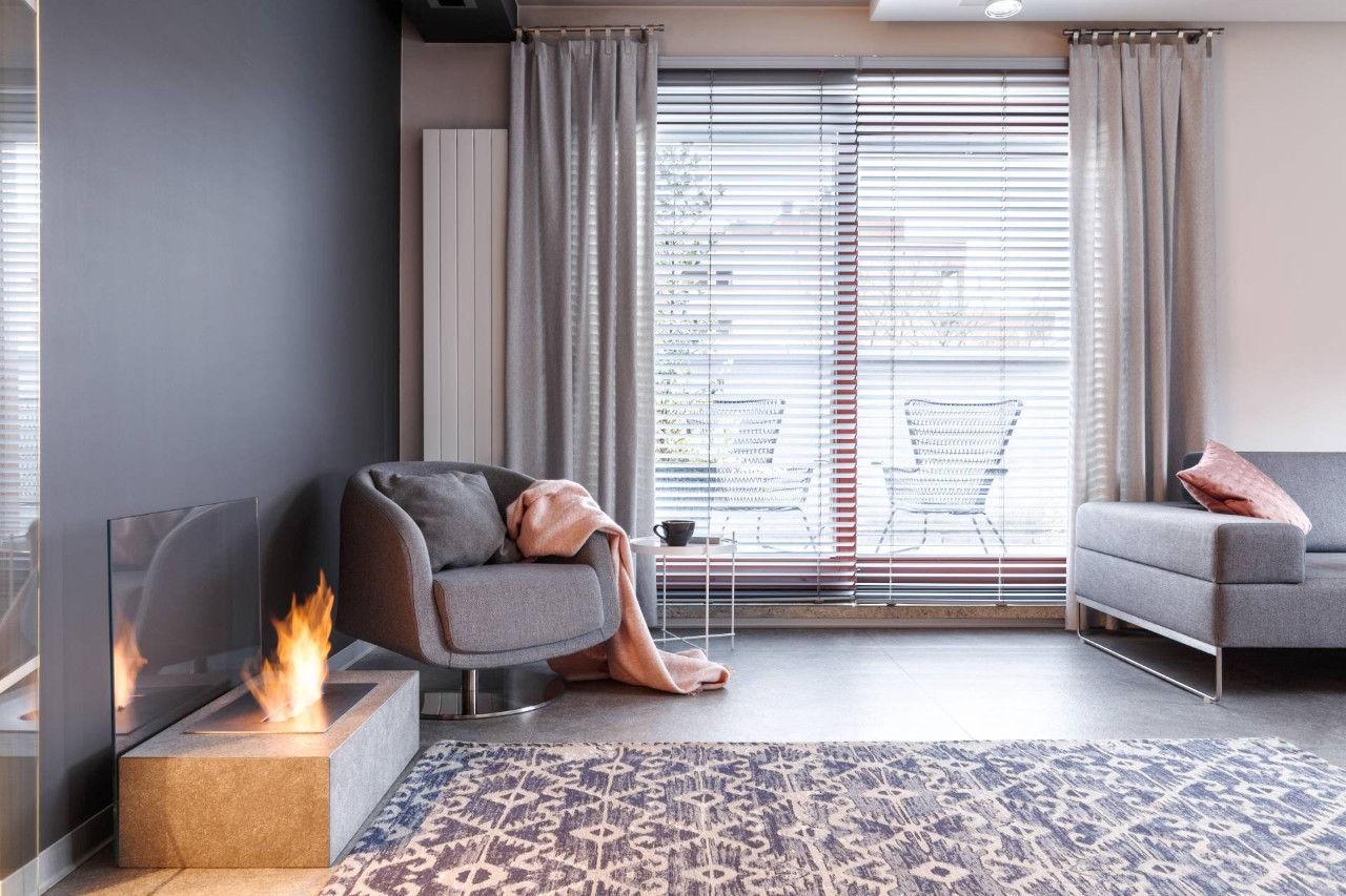 Living room window adorned with blinds drapes in a gray living room with a fireplace on at Geneva's Interiors near Federal Way, WA